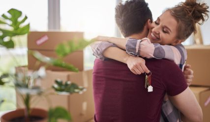 Happy couple with keys of new apartment
